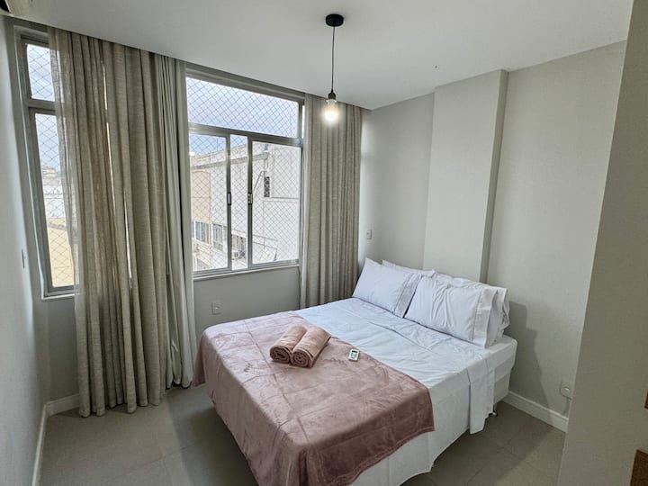 Chambre avec un lit double, la climatisation et une vue latérale sur la mer.