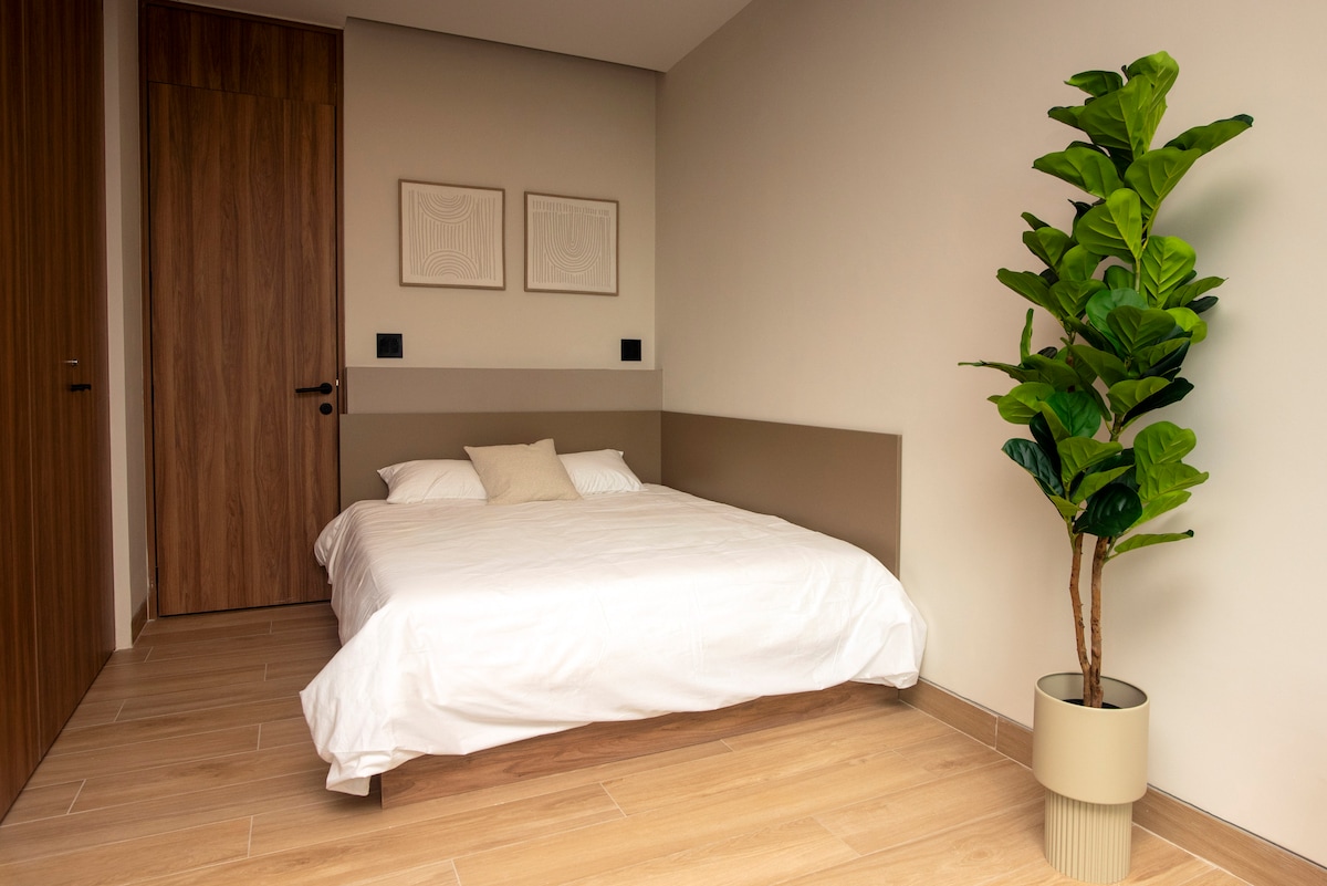 Habitación con cama matrimonial y baño completo privado. Separada de la sala por cortina, ofrece practicidad y confort en un espacio versátil para descansar durante tu estancia.