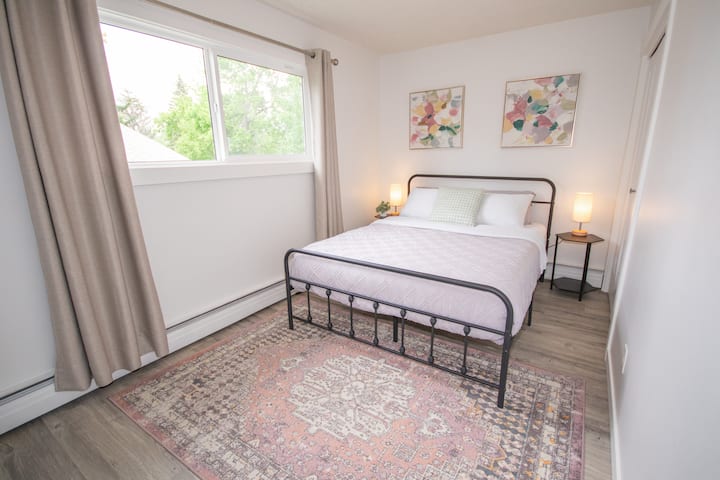 Bright and spacious bedroom with a queen bed and lots of natural light.