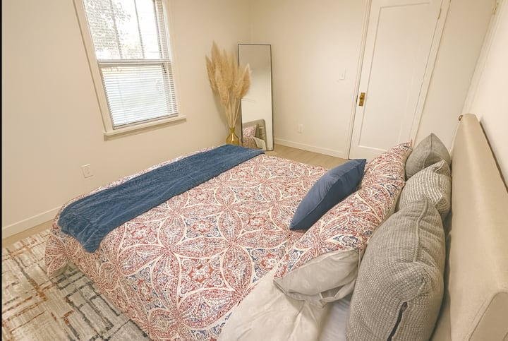 ห้องนอนที่ 2 ที่อบอุ่นนี้มีเตียงนุ่มพร้อมผ้าปูที่นอนสีสันสดใส กระจกสูงเต็มตัวที่มุมห้อง และตู้เสื้อผ้าขนาดเล็กสำหรับของใช้จำเป็น การตกแต่งอย่างเรียบง่ายและแสงไฟสีอ่อนช่วยสร้างบรรยากาศที่พักผ่อนและผ่อนคลายได้อย่างสบายใจ ✨