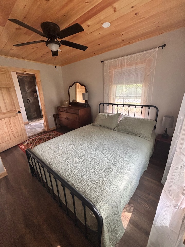 غرفة نوم مجهزة بسرير بحجم كوين وخزانة ملابس وخزانة ومكيف ميني سبليت للتدفئة أو التبريد، بالإضافة إلى مروحة سقف؛ وحمام داخلي. 