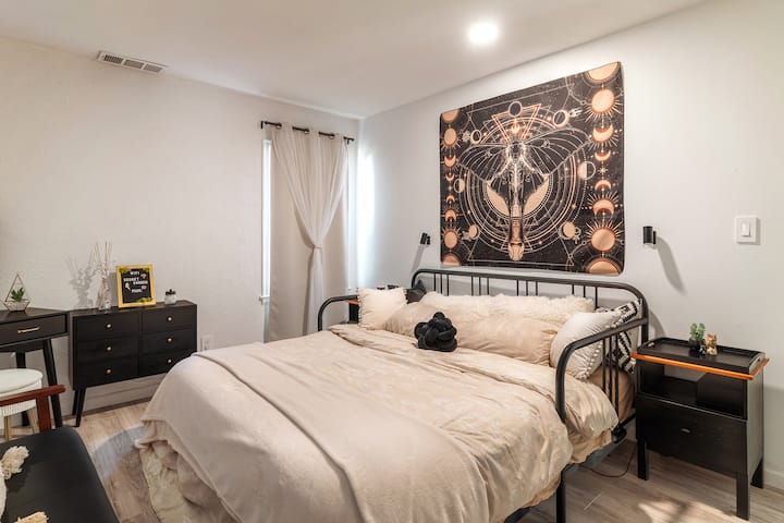 Dormitorio con cama tamaño king, tocador y armario grande.