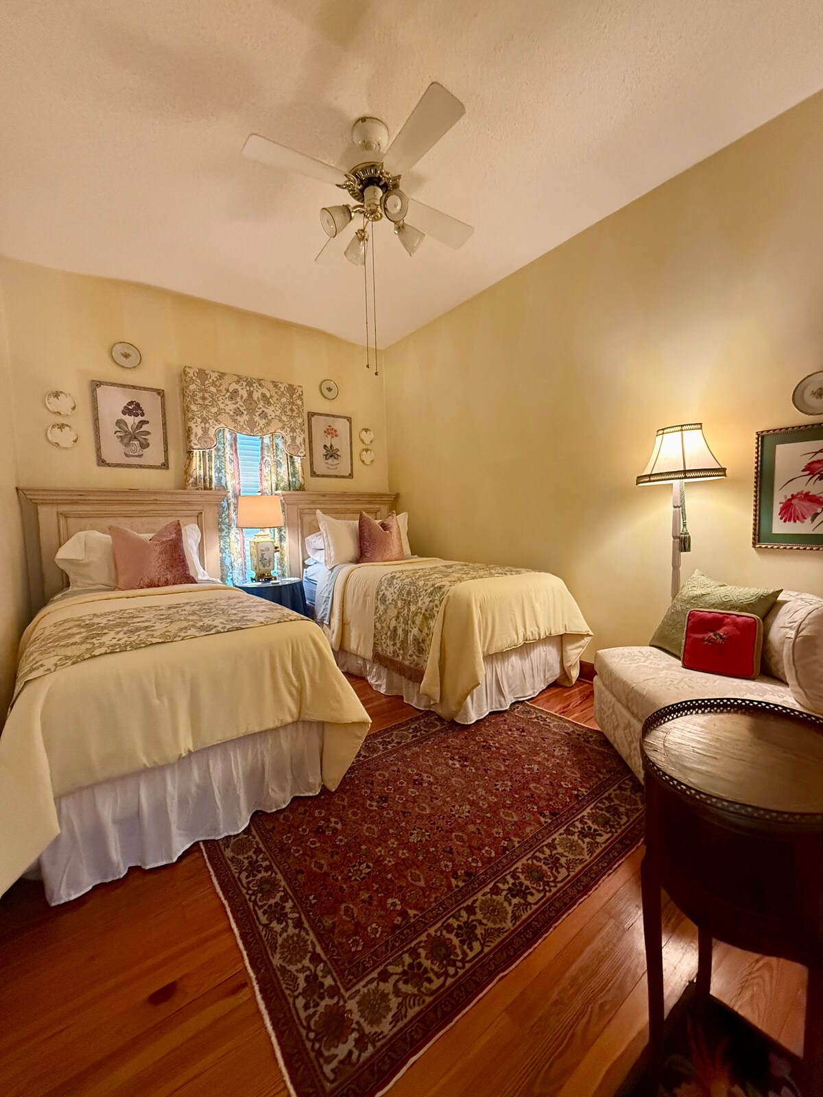 מקום אירוח מואר בקומה התחתונה עם תקרות גבוהות, מיטות נפרדות וגווני צהוב עליזים. 