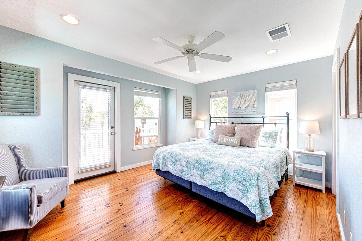 ჰაეროვანი საძინებელი რბილი განათებითა და თბილი ხის იატაკით.