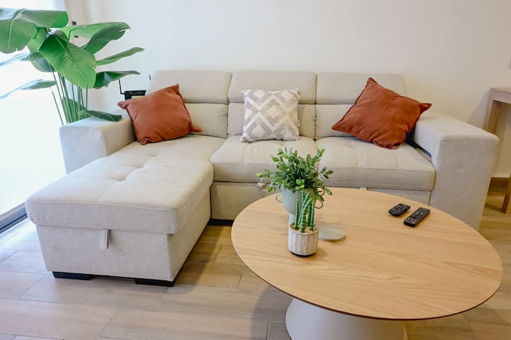 Sala de estar + Smart TV Nano Cell 4K con las aplicaciones más comunes para que puedas disfrutar de Netflix, Prime Video, Disney+ Sofá cama disponible con almacenamiento en el lado del salón, 2 puffs y la mesa de centro. Aire acondicionado disponible + ventilador para el interior o para la terraza. 