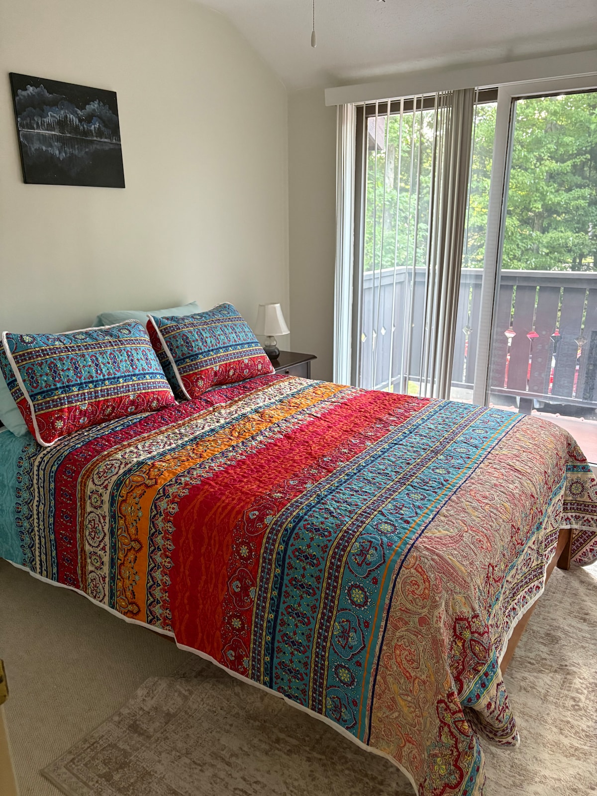 Chumba cha kulala juu kilicho na kitanda na roshani yenye ukubwa kamili kinachoangalia eneo la njia ya gari ya nyumba.