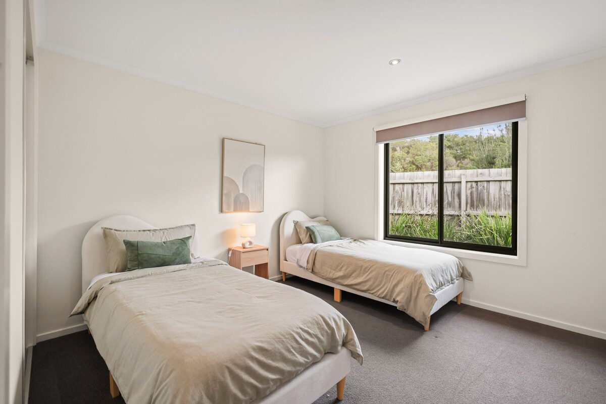 Მიმზიდველი ოთახი ორი კომფორტული საწოლითა და ნათელი ფანჯრით