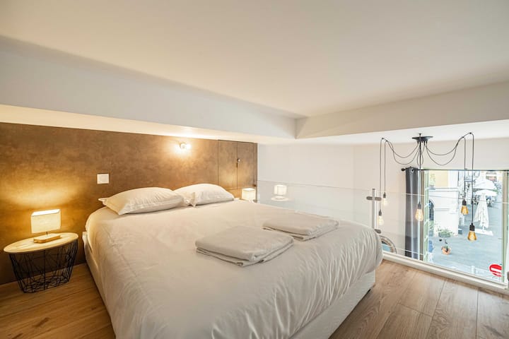 חדר שינה בקומת ביניים עם מיטה זוגית ואחסון