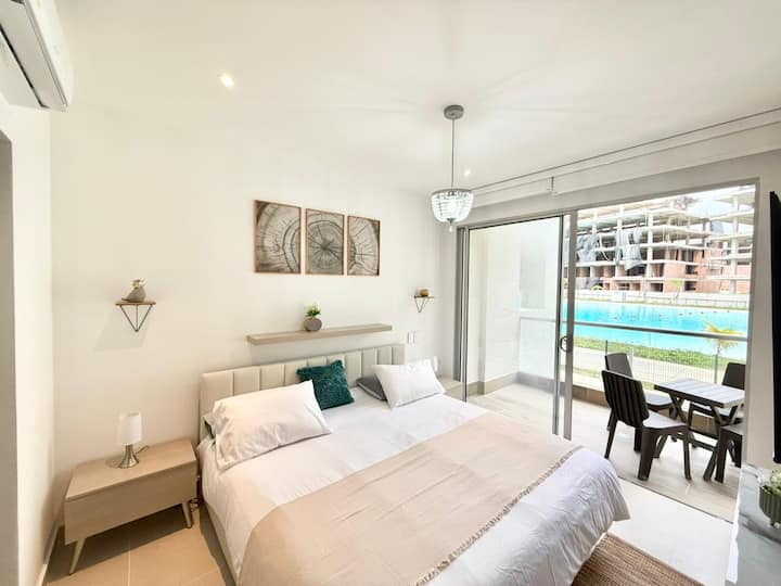 Sink into a cozy king bedroom designed for pure comfort and romance. Enjoy a plush mattress, cloud-soft pillows. Step onto the private balcony, where breathtaking lagoon views and tactile LED lighting create the perfect atmosphere for magical sunsets