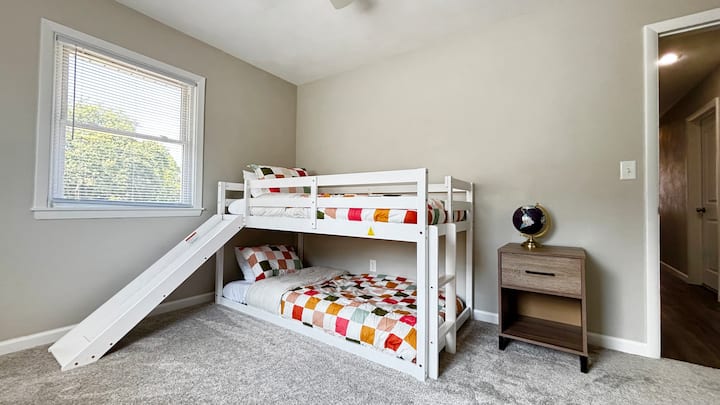 明亮宽敞的双层床房，配备两张单人床、内置滑梯和令人愉悦的床上用品。 包括带夜灯的音响机，让孩子们可以舒适地入睡。