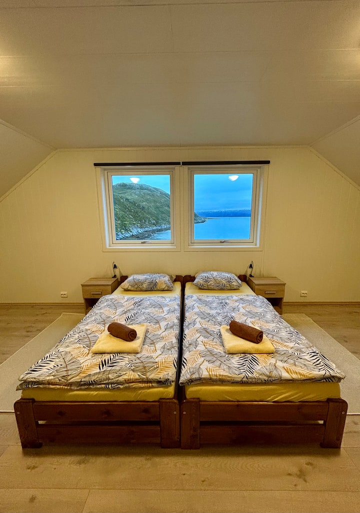 18 m² bedroom with 2 single beds, large windows, wardrobe with stunning sea and mountain views. Bright, minimalist design with comfortable armchair and soft bedding.