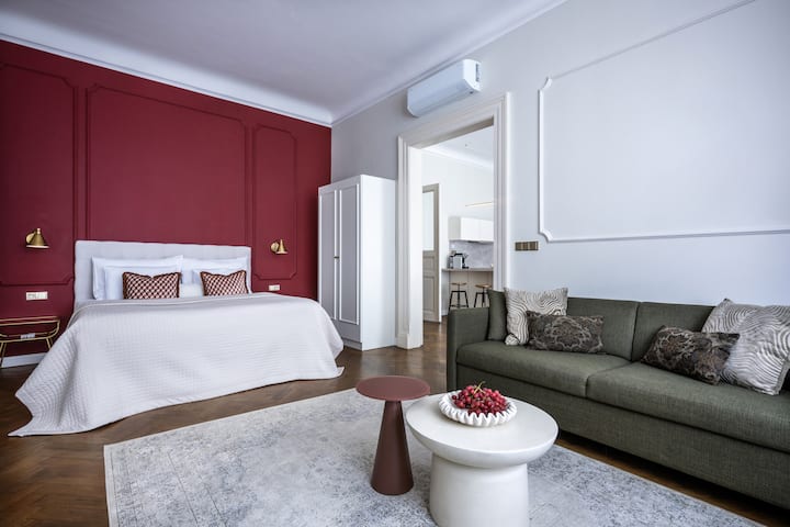 Elegante suite con zona lounge, parete con accenti audaci e comfort dell'aria condizionata