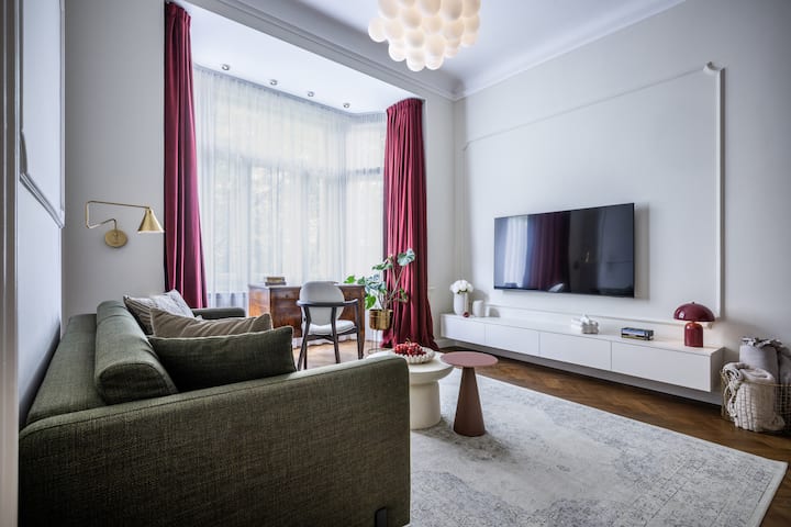 Elegante salotto con vetrate, soffitti alti e un'elegante zona TV