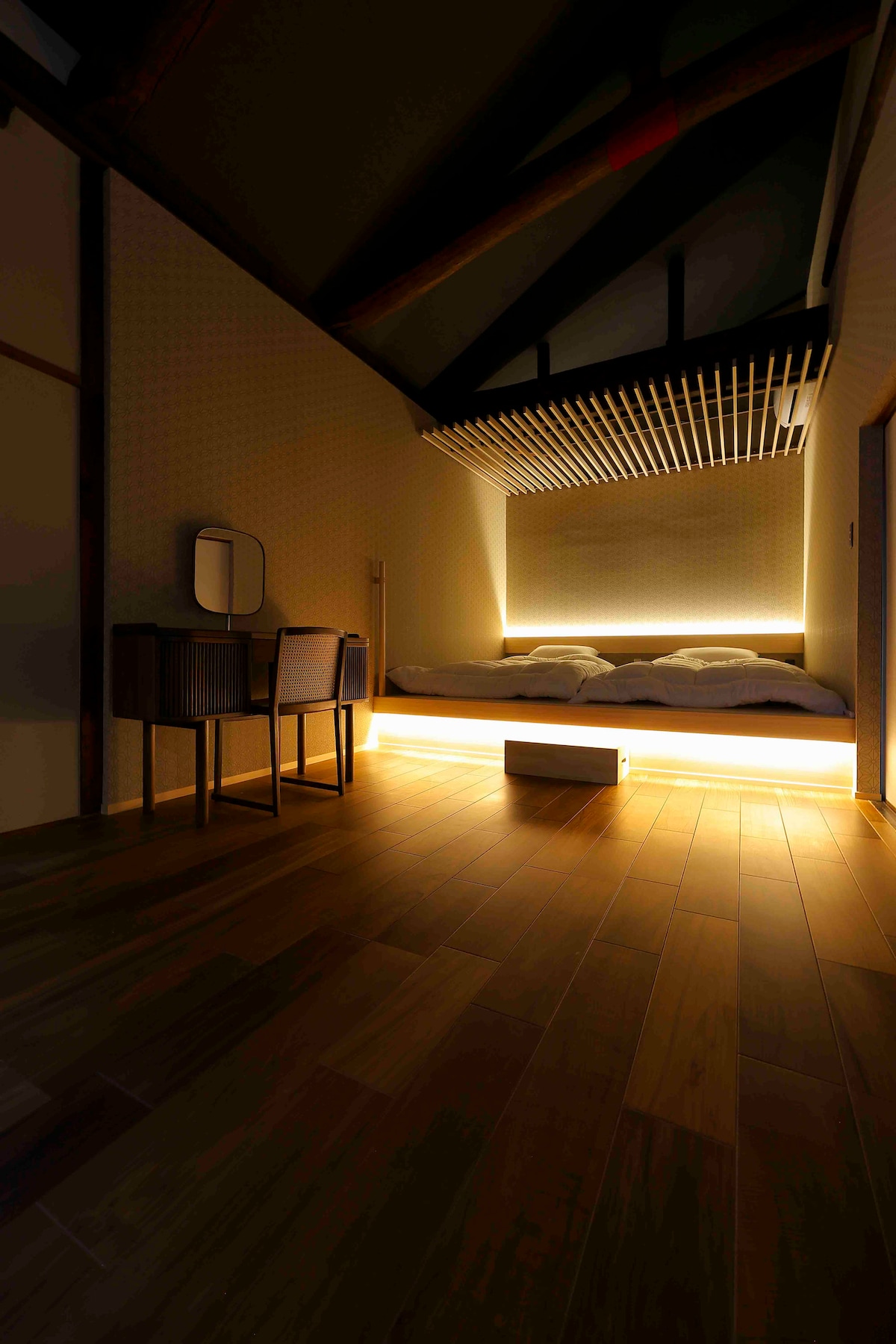 18㎡ bedroom. Warm and soft lighting sets off the tatami bed, paired with a simple dressing table and wooden furniture, creating a quiet and comfortable atmosphere.Please quietly feel the unique tranquility of Kyoto Machiya at night.