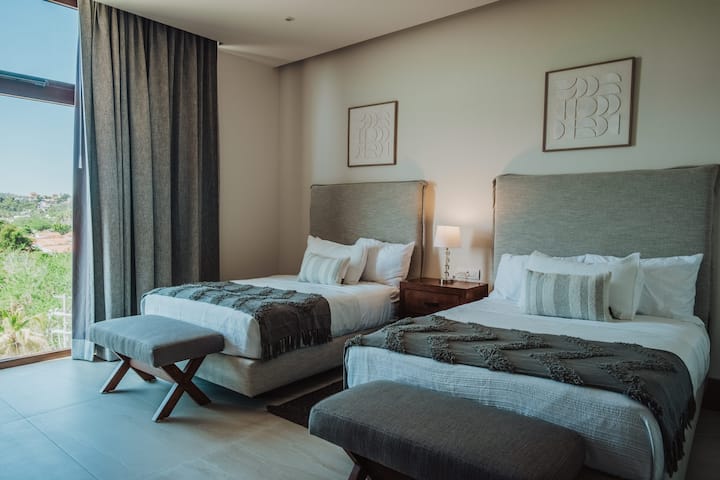 chambre avec deux lits queen size et salle de bain privée 