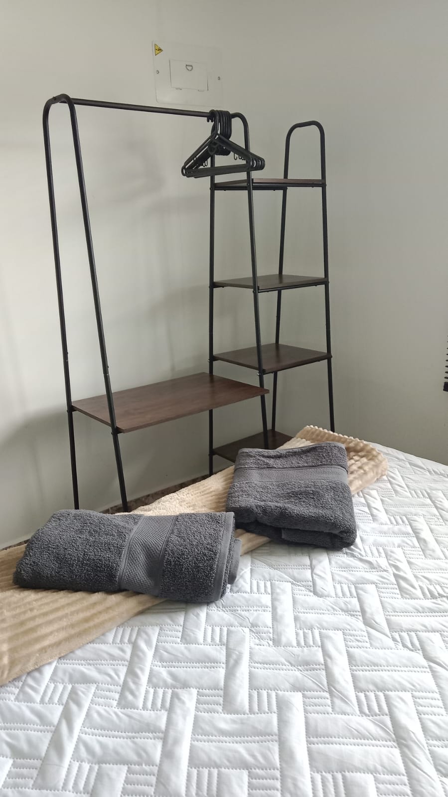 خزانة ملابس مفتوحة عصرية وعملية، مثالية لتنظيم ملابسك واستيعابك بشكل مريح أثناء إقامتك.