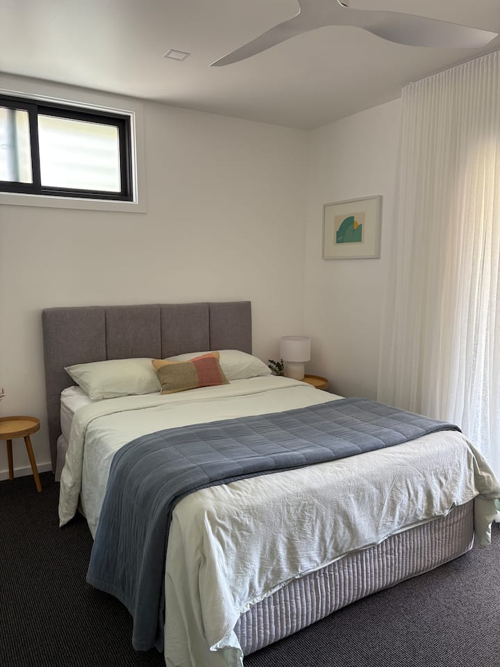 Segundo dormitorio con cama tamaño queen y acceso directo a la terraza trasera. 