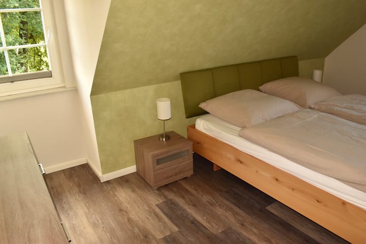 Dhomë gjumi komode me tone natyrale ofron hapësirën ideale për pushim dhe qetësi.