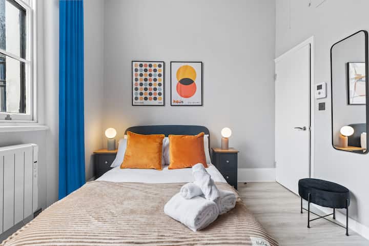 Comodo letto matrimoniale con cuscini morbidi, lenzuola fresche e illuminazione calda