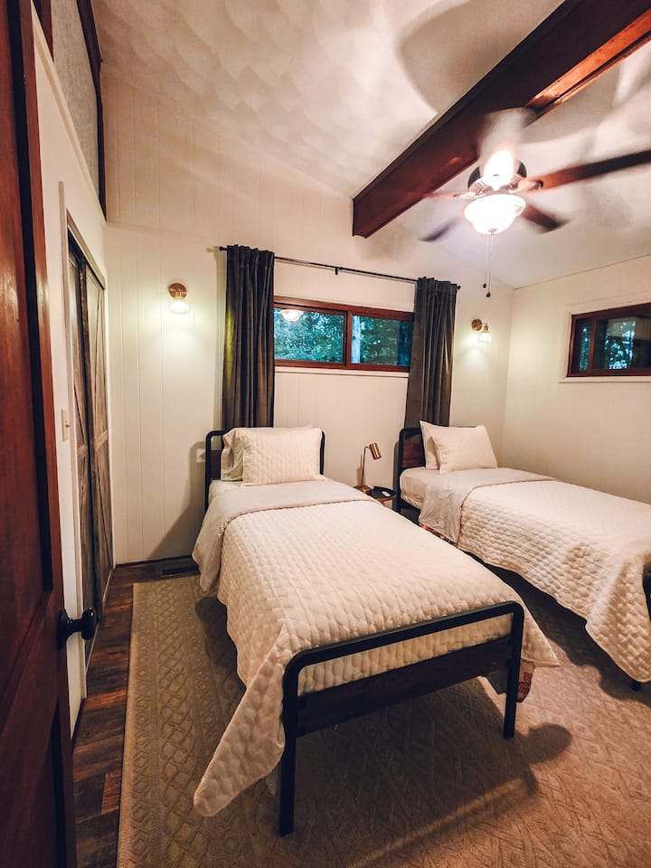 Segundo dormitorio ubicado en el piso principal. Se pueden juntar dos camas individuales para formar una cama tamaño king, si lo prefieres, pero avísanos antes de la llegada para que podamos organizarlo. Espacio en el armario, juego adicional de sábanas y cortinas opacas. 