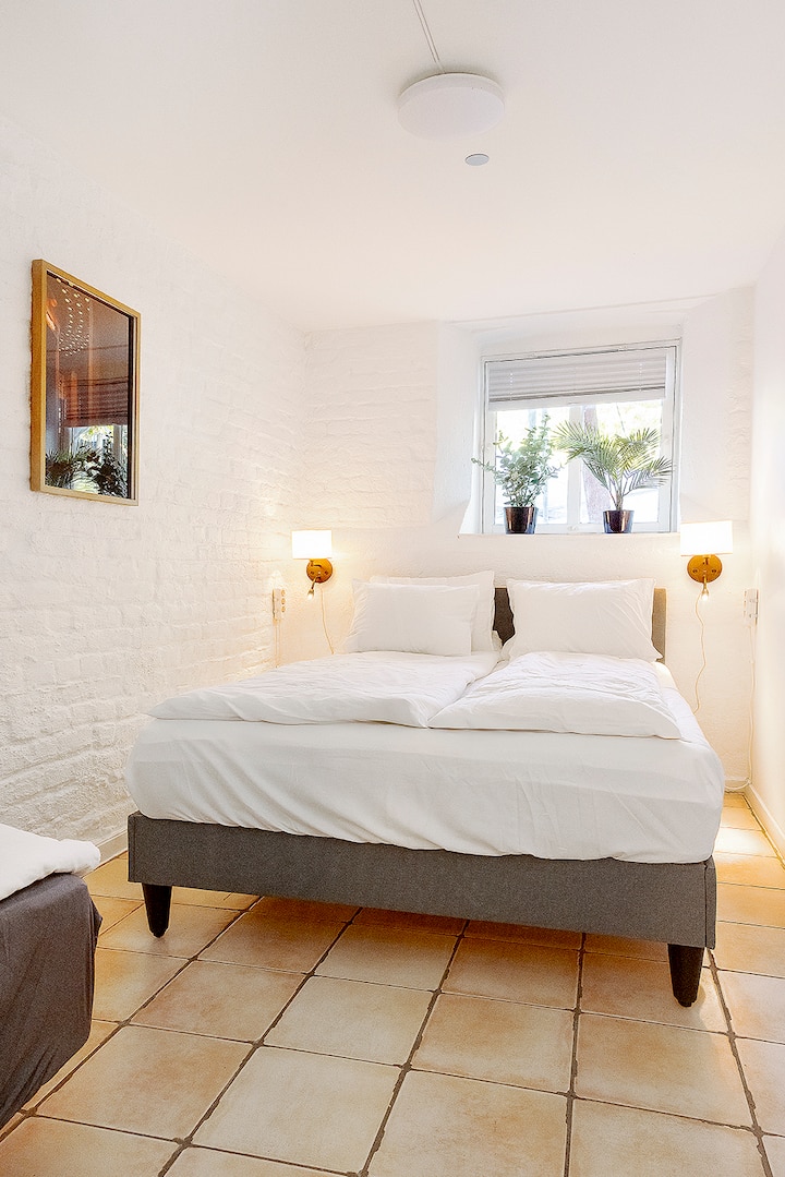 חדר שינה 1 – מתאים למשפחות
3 מקומות לישון: מיטה זוגית אחת (140x200 ס"מ) + מיטת יחיד אחת (90x200 ס"מ)
נוף לגינה עם תריסים בשלט רחוק
מראה בגובה מלא, ווים לבגדים ומייבש שיער
4 שקעי חשמל בכל צד של המיטה לטעינה במהלך הלילה