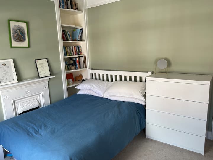 חדר זוגי מואר גדול עם שולחן, קולב בגדים ושידה 