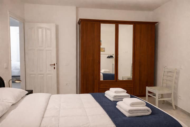 Camera matrimoniale luminosa con letto comodo, armadio capiente e biancheria inclusa. Spazio ordinato e silenzioso, ideale per riposare dopo una giornata sul Trenino del Bernina.