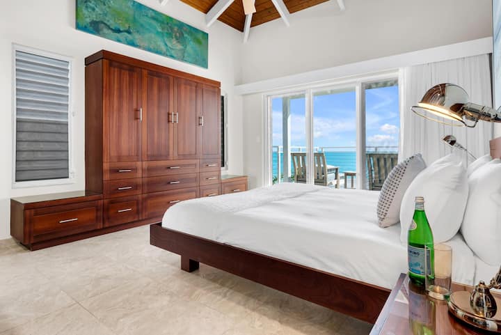Dormitorio principal en el piso superior con baño privado y balcón, que ofrece hermosas vistas al mar, al amanecer y al atardecer.