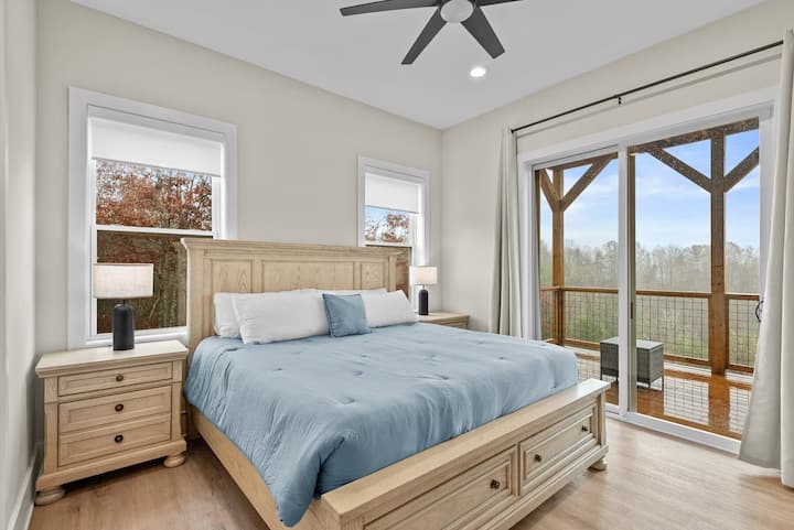 卧室明亮通风，配有加大双人床、现代天花板风扇和滑动门，可通往私人阳台，可欣赏宁静的森林景观。 舒适与自然的完美融合，让您享受宁静的住宿体验。