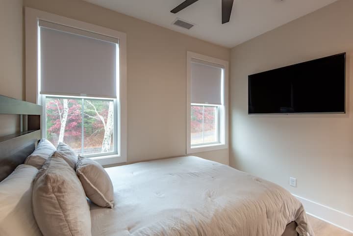 这间宁静的客房配有豪华标准双人床、中性床单、吊扇、遮光帘和壁挂电视。 徒步或在新河上玩轮胎漂流后，醒来欣赏树木景观，然后在这里放松身心。