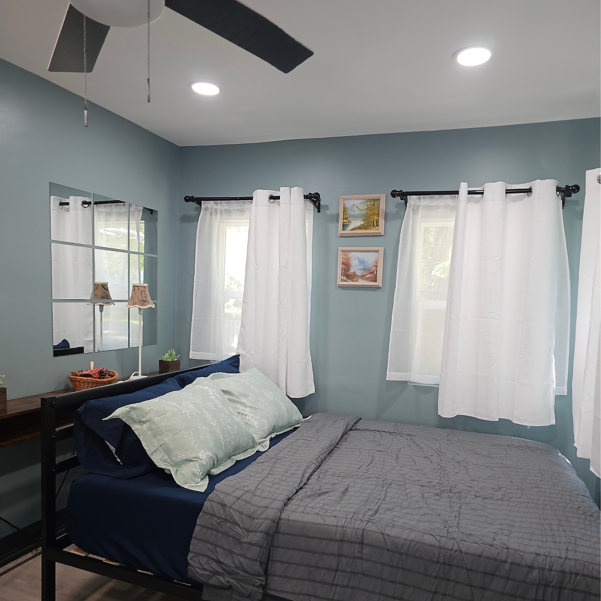 ห้องนอนที่ดูดีมีสไตล์ มีเตียงควีนไซส์ที่ดูอบอุ่นและหน้าต่างหลายบานที่ช่วยให้แสงธรรมชาติเข้ามาได้เพียงพอ คอนโซลที่เรียบหรูติดผนังมีปลั๊กสะดวกสบายสำหรับชาร์จโทรศัพท์หรืออุปกรณ์อื่นๆ