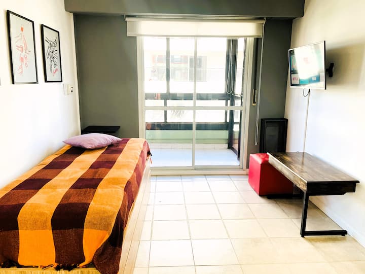 Living-cocina-comedor integrados. Espacio de living, con TV, con salida al balcón. Cama de una plaza con cama marinera.