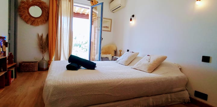 Chambre épurée et climatisée avec balcon et vue sur le village. Le dressing attenant offre un espace de rangement appréciable pour les séjours d'une semaine ou plus.