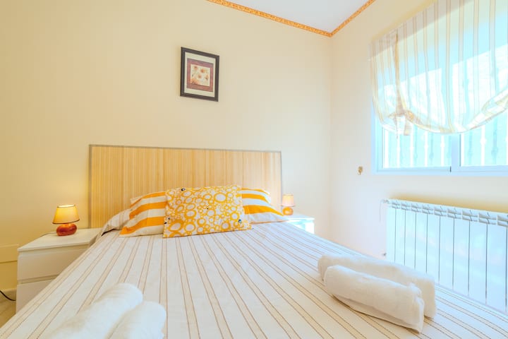 Dormitorio 4 con cama de matrimonio y ropa de cama a rayas: acogedor y muy luminoso.