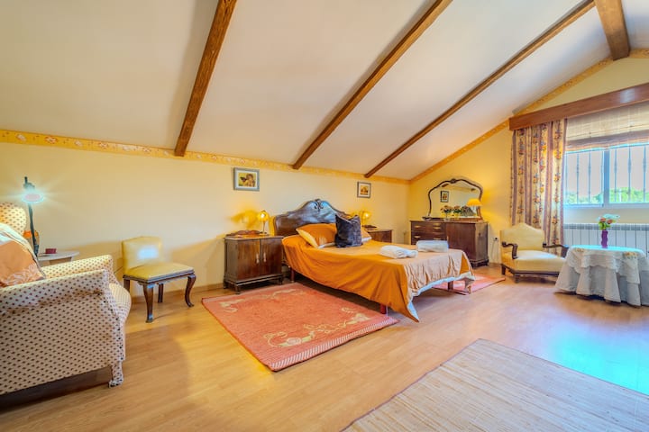 Dormitorio 1 con cama de matrimonio, butaca y ventana: luminoso y acogedor.