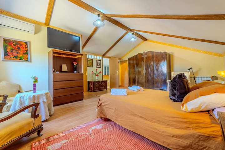 Dormitorio 1 con cama, armario de madera y TV: amplio y muy luminoso.