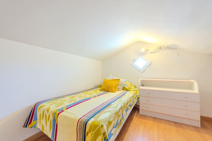 Dormitorio 5 abuhardillado con cama individual: acogedor y con mucha luz natural.