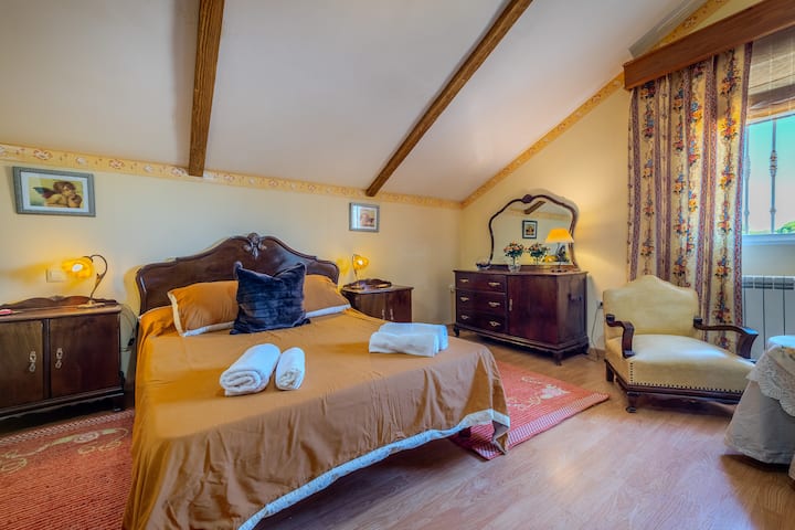 Dormitorio 1 abuhardillado con cama de matrimonio y cómoda: cálido y muy espacioso.