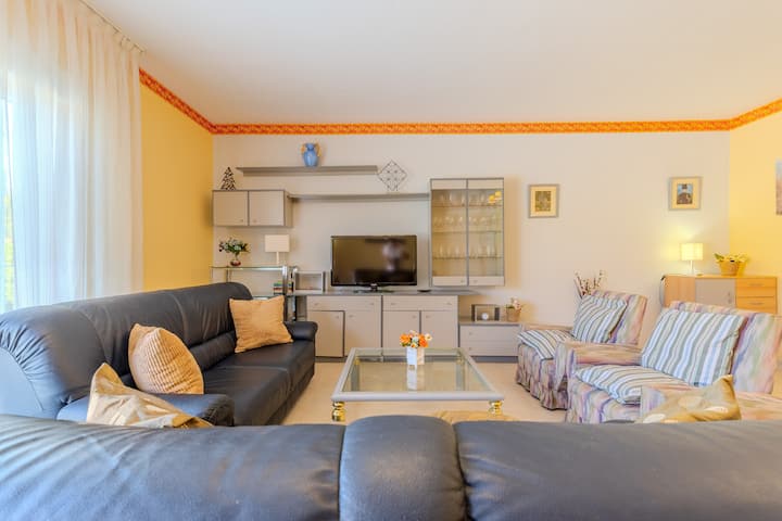 Zona de estar con sofás, TV y buena luz: rincón confortable para relajarse.