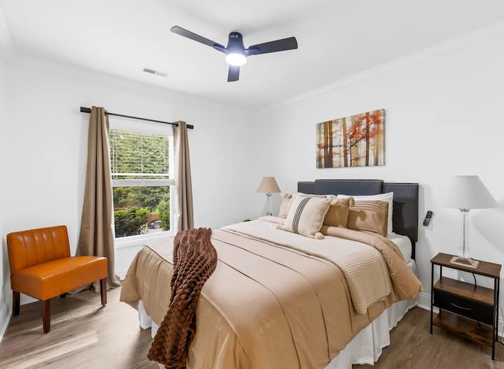 מיטת קווין סייז מפוארת עם תחנת טעינה על שולחנות צד