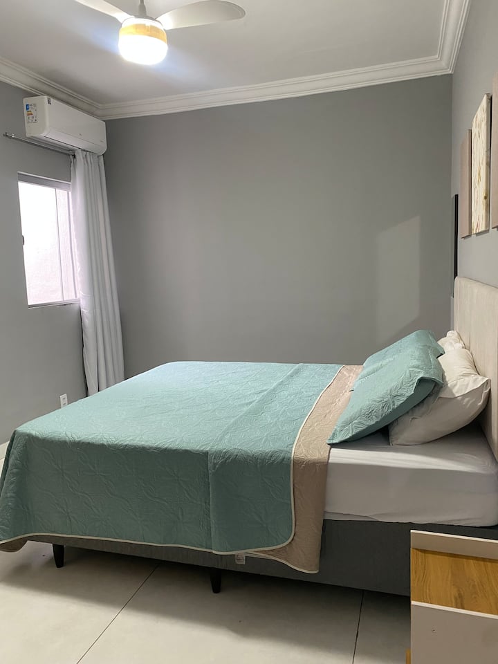 Bedroom with a queen-size bed, air conditioning and bed linen for a comfortable stay.