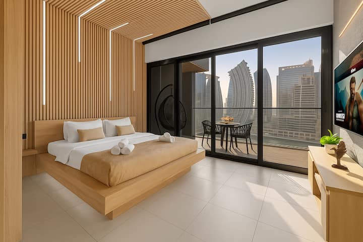 Amplio y luminoso dormitorio con moderna cama tamaño king y cálidos tonos naturales con acceso directo al balcón y vistas impresionantes al Burj Khalifa para una estancia inolvidable.
