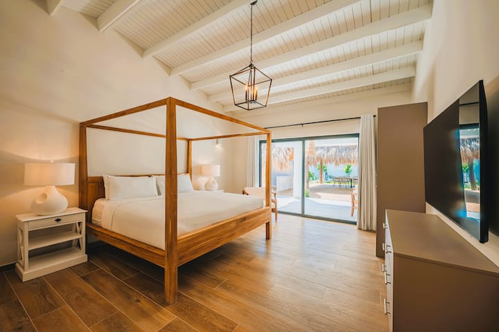 غرفة نوم رئيسية 1 تطل على حمام السباحة مع حمام داخلي وسرير مظلة وخزانة ملابس كبيرة وخزانة ملابس وتلفزيون 65 بوصة