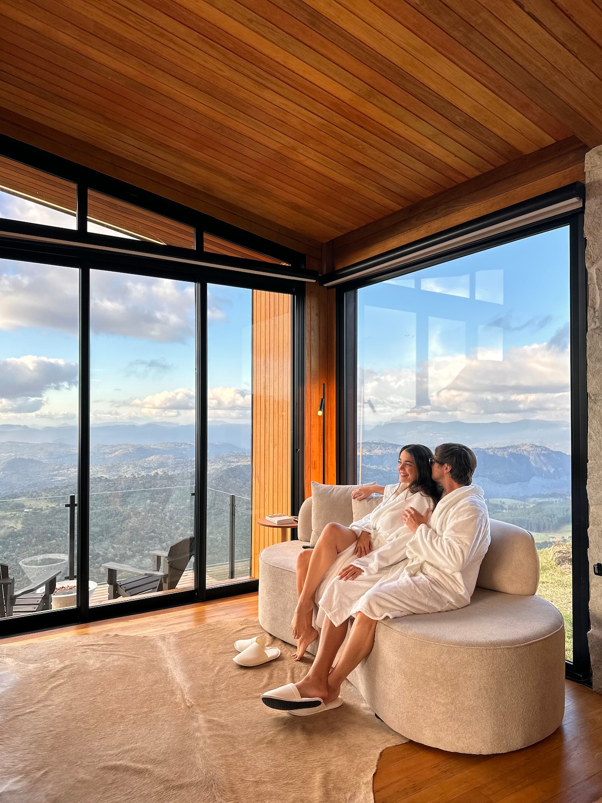 Sala de estar com um sofá, uma TV e uma vista magnífica.