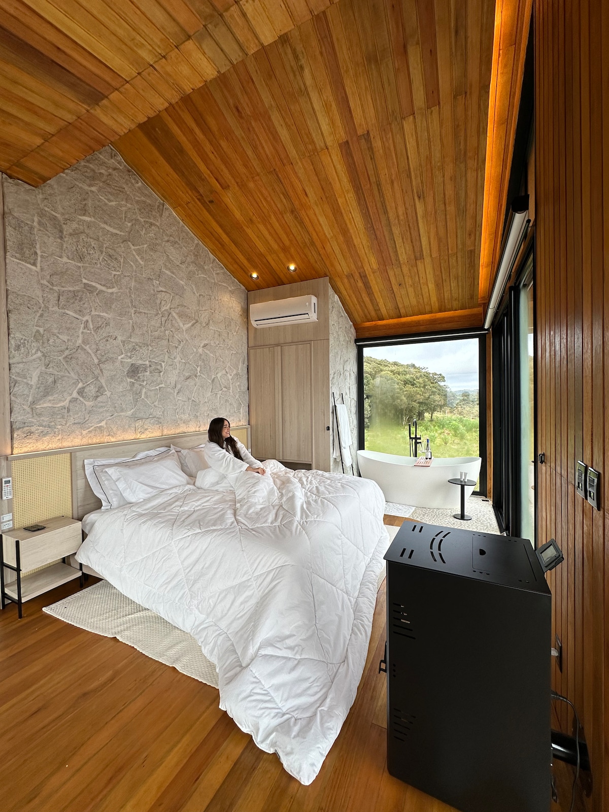 quarto aconchegante com roupa de cama e lareira para aquecer a noite.