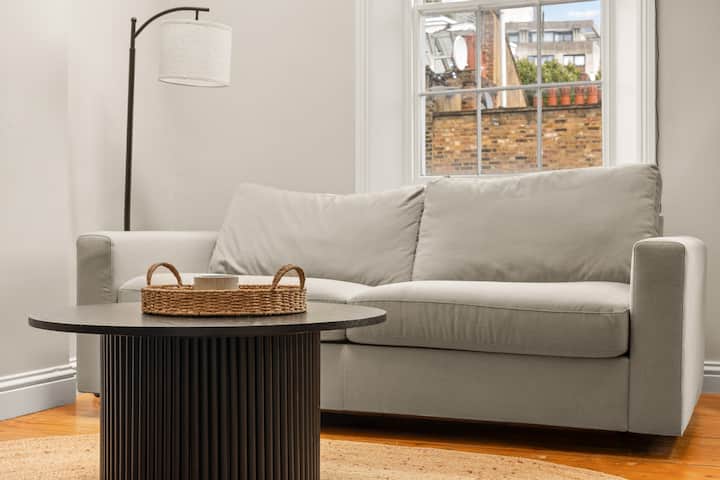 ห้องนั่งเล่น: ห้องนั่งเล่นที่มีแสงแดดสาดส่องพร้อมเตียงโซฟาที่สะดวกสบายและทีวี มีจุดที่อบอุ่นและน่าอยู่สำหรับพักผ่อนหรือผ่อนคลายหลังจากสำรวจเมือง