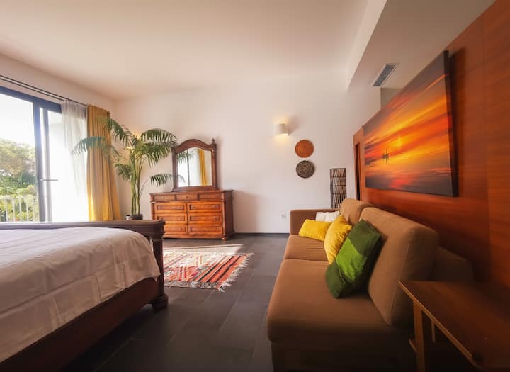 Chumba hiki kikuu kina kitanda kikubwa, eneo la mapumziko na roshani ya kujitegemea inayoangalia bustani na bwawa la kuogelea. Utafurahia starehe kubwa, uhifadhi wa kutosha na mapambo mahiri.