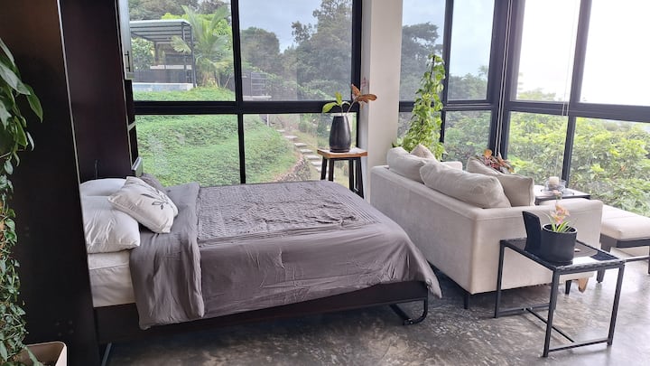 Ocean-View Murphy Bedroom (Queen Bed). By night, the living room transforms into a private retreat with a queen Murphy bed — offering comfort and breathtaking views from sunrise to starlight.