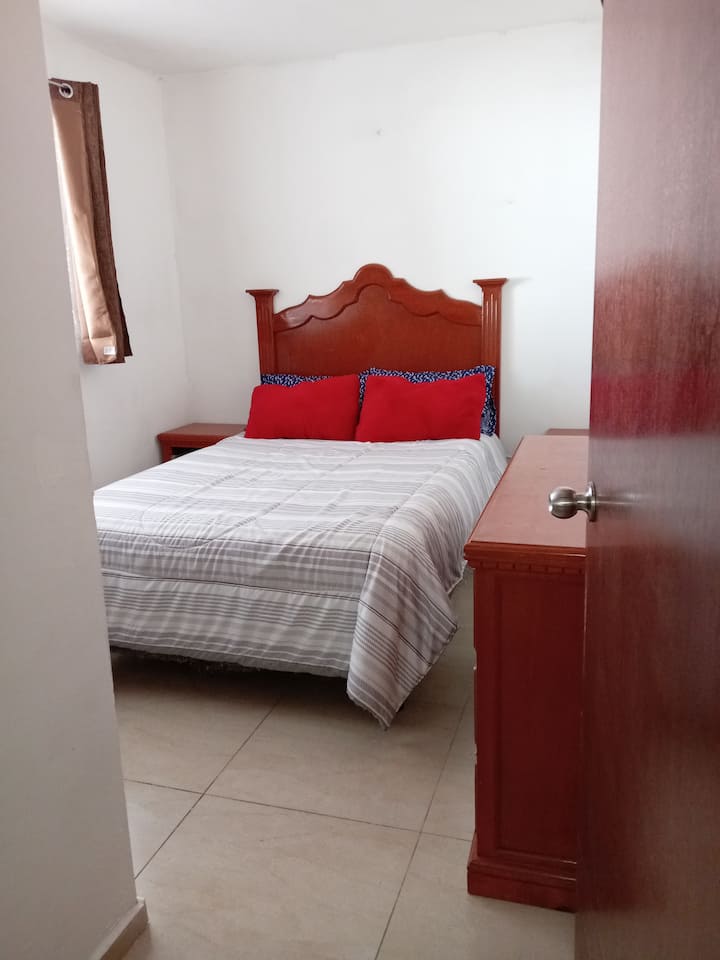 Habitación con pantalla, tocador y clóset con ventana a la cochera