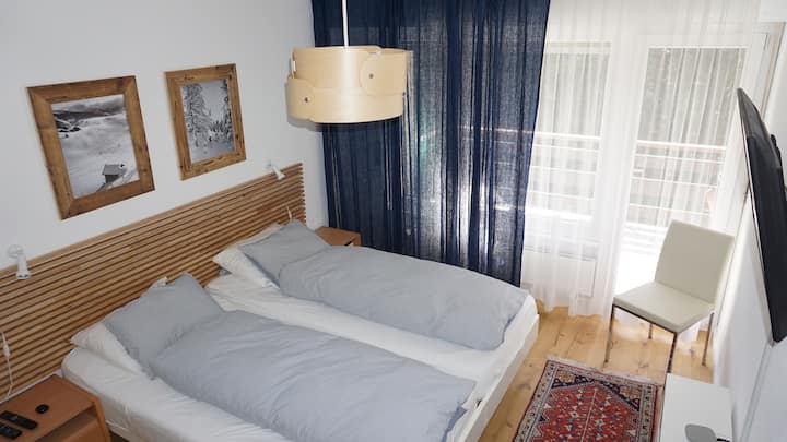 Svetlá a pohodlná spálňa s dvoma samostatnými posteľami vytvára pokojné a odpočinkové útočisko po dni strávenom v horách.